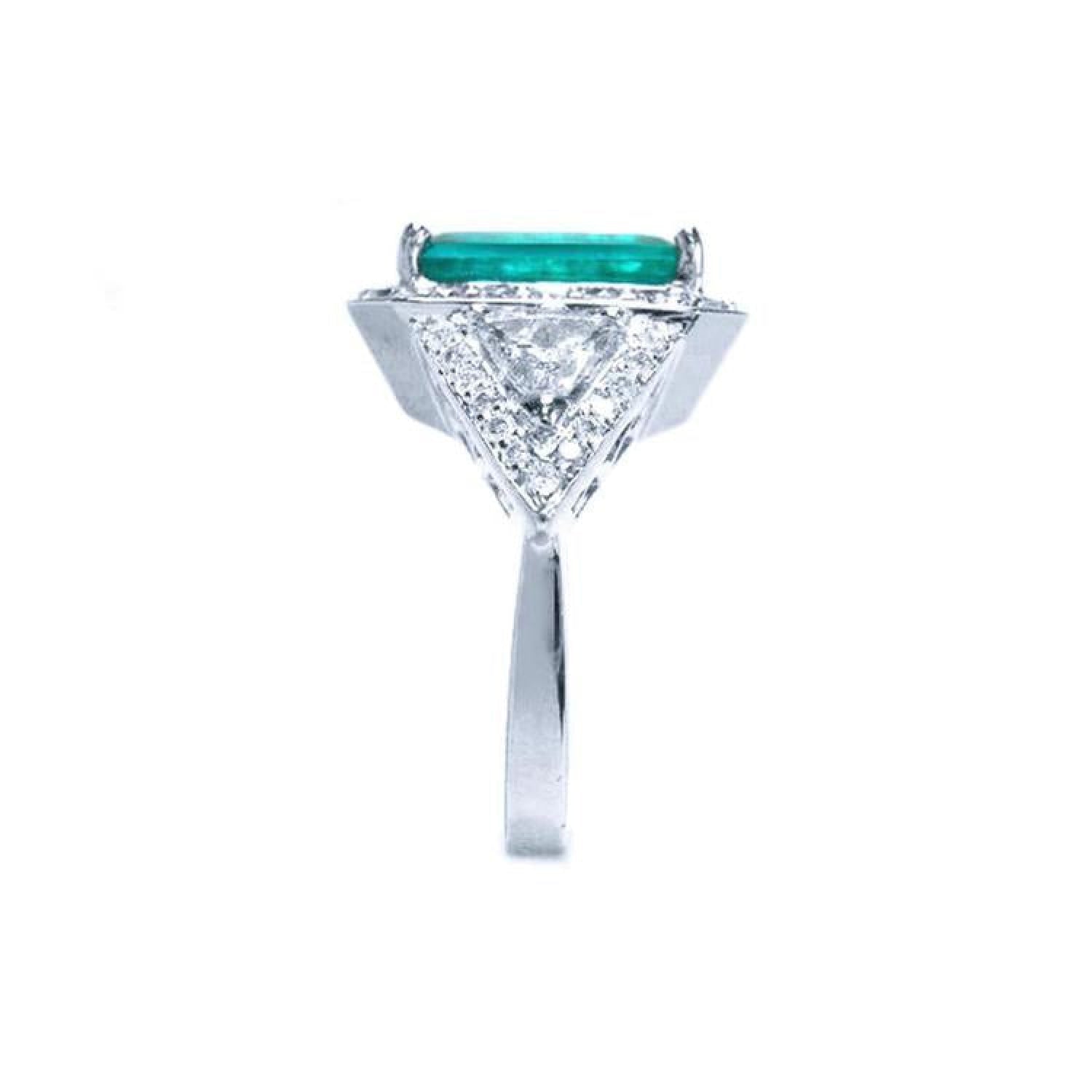 18K white gold ring with a rectangular emerald center stone, surrounded by diamonds and trillion cut sides.