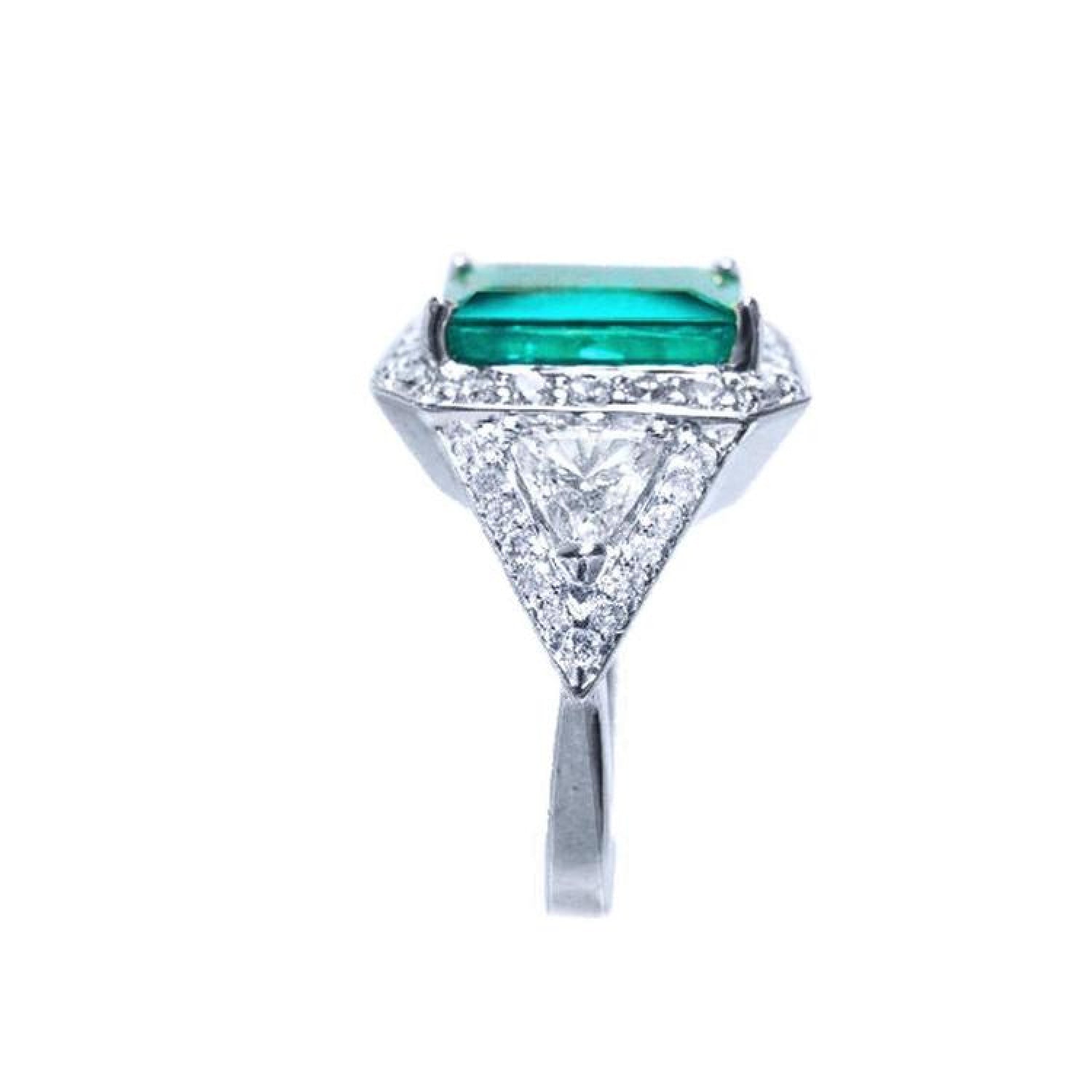 18K white gold ring with a rectangular emerald, diamond halo, and trillion side diamonds.
