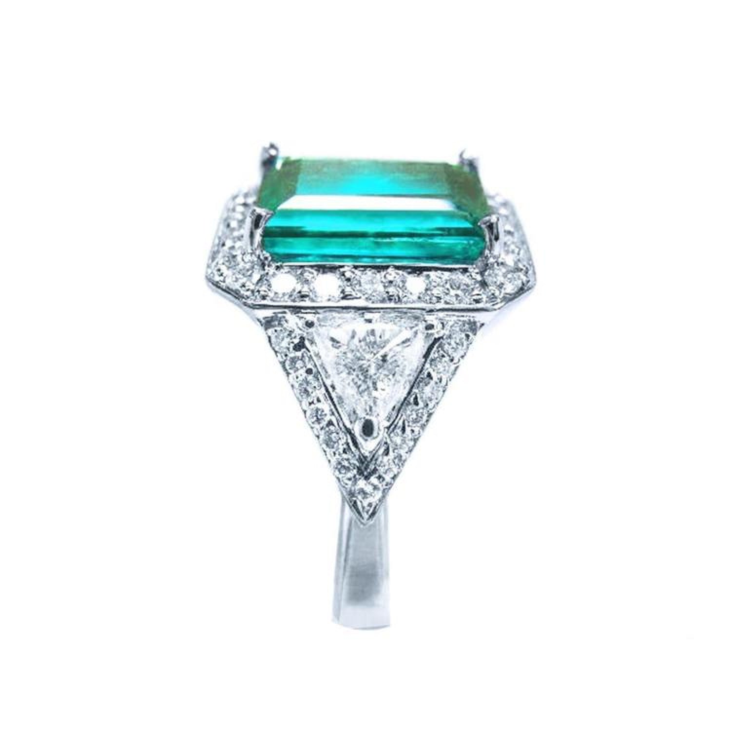 GIA certified 3.98 ct. emerald and diamond ring in 18K white gold with halo and trillion side stones.
