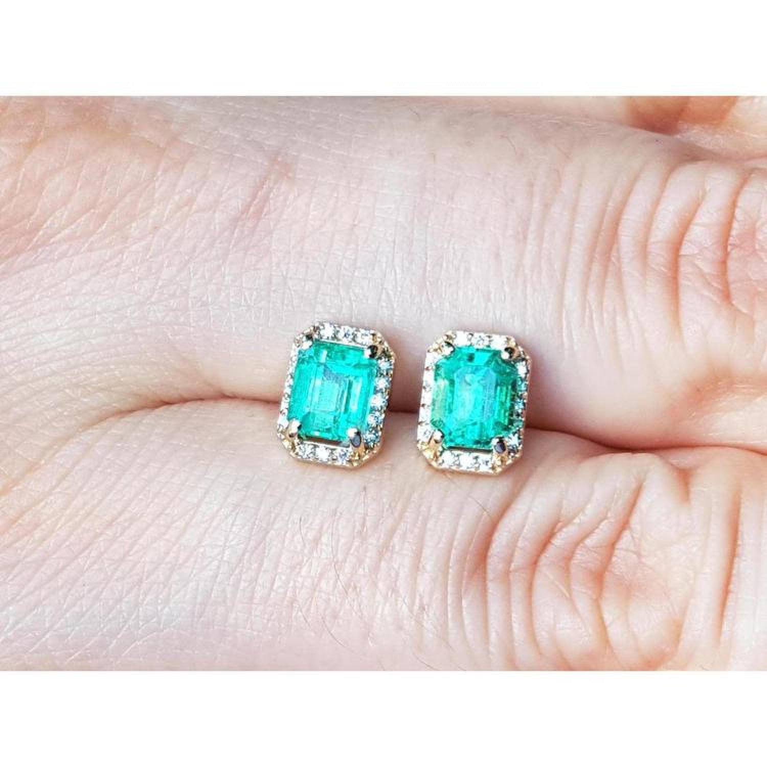 1.41 ct. rectangular Colombian emerald halo stud earrings with diamonds in 14k yellow gold.