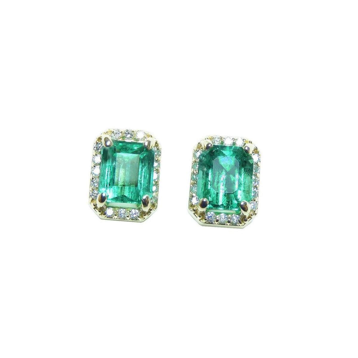 Pair of natural emerald stud earrings halo diamond on a front position, plain top view.