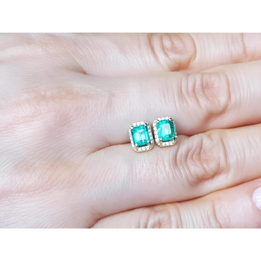 Rectangular Colombian emerald and diamond halo stud earrings in 14k yellow gold.