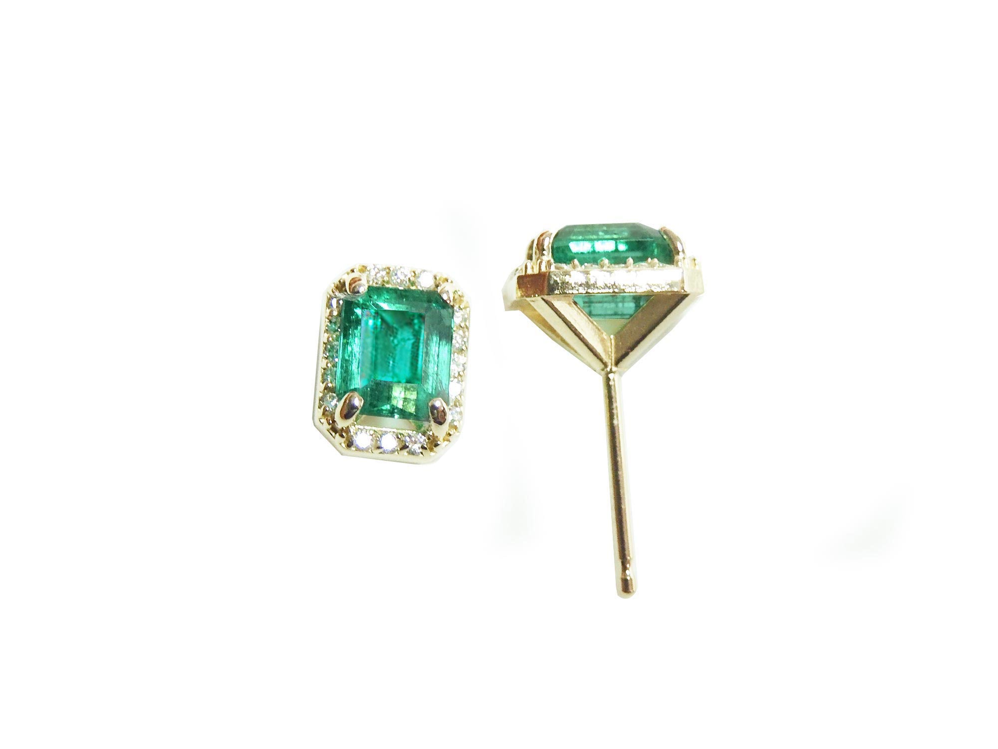 Pair of emerald green gemstone earrings with gold settings on a white background.