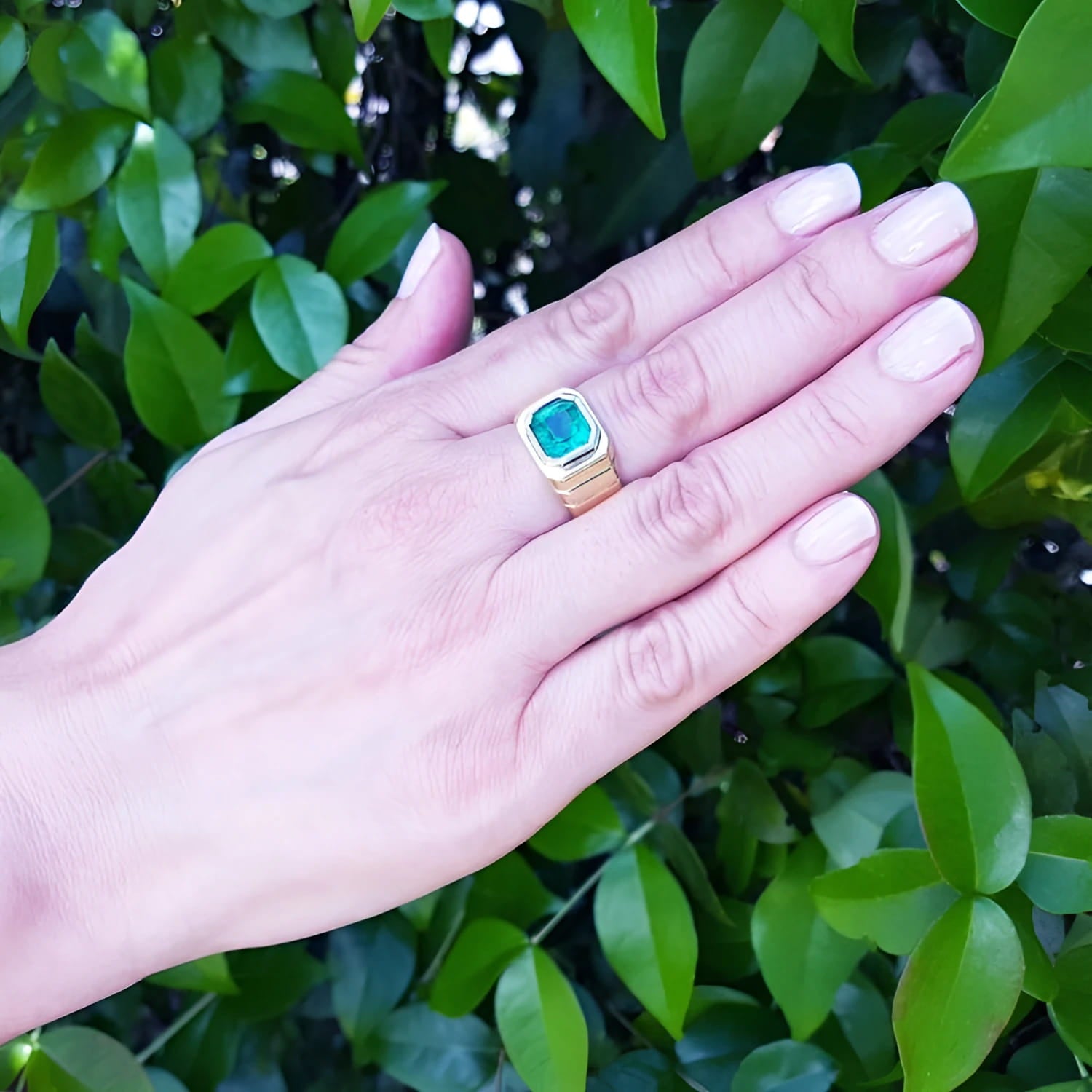 Men's 18K yellow gold ring with a rectangular, medium-deep green emerald in a full bezel setting.