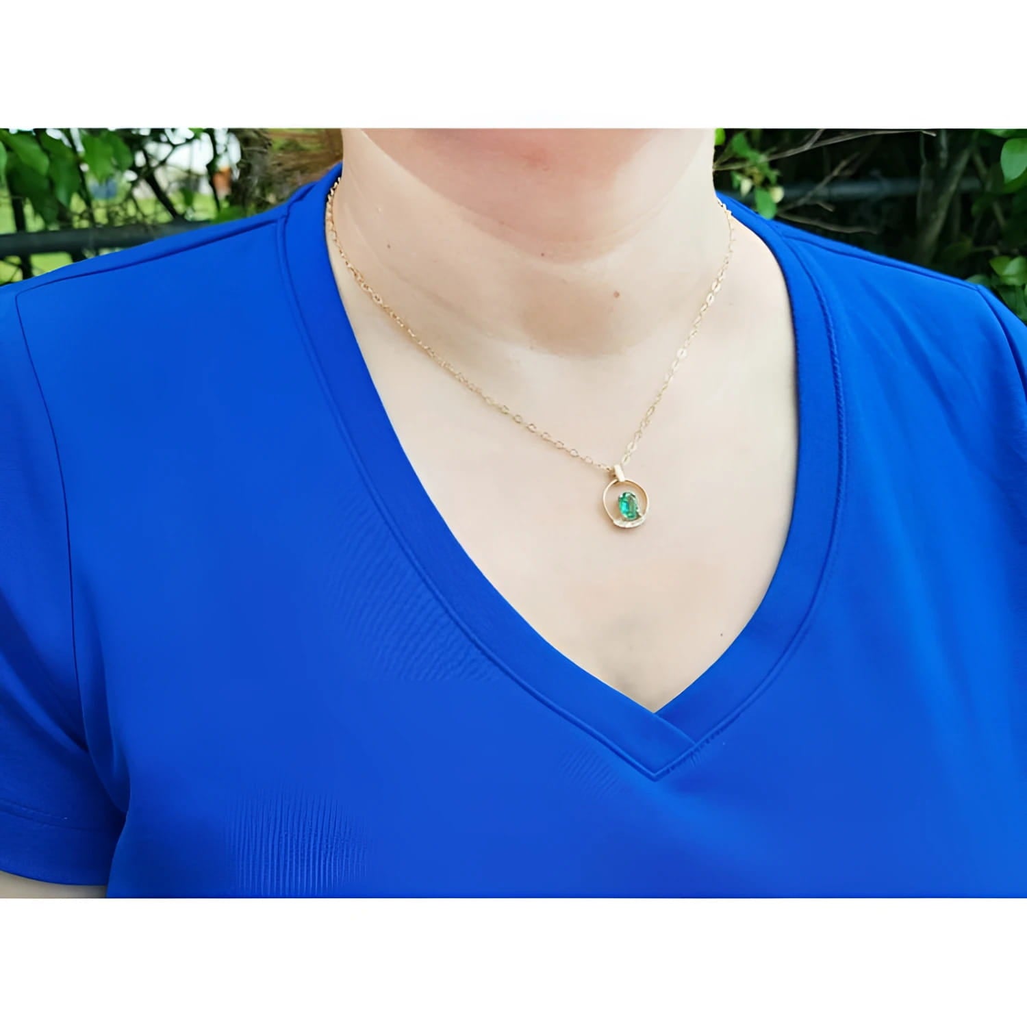 14k yellow gold necklace with a round pendant featuring a natural Colombian emerald and diamond accent.