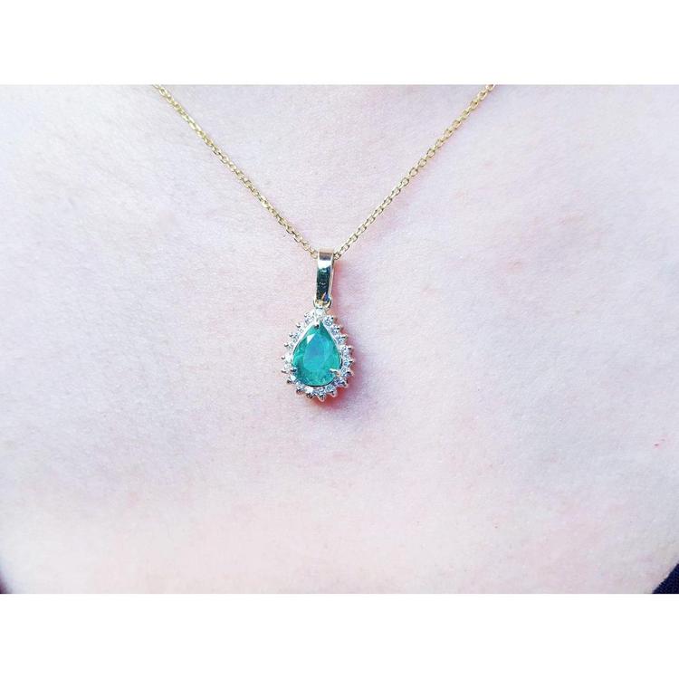 Pear-shaped Colombian emerald pendant with halo diamonds on a 14K yellow gold chain.