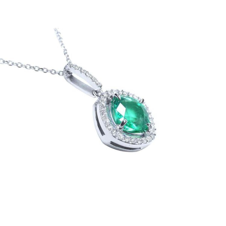 Cushion-cut Colombian emerald pendant with diamond halo in 14K white gold.