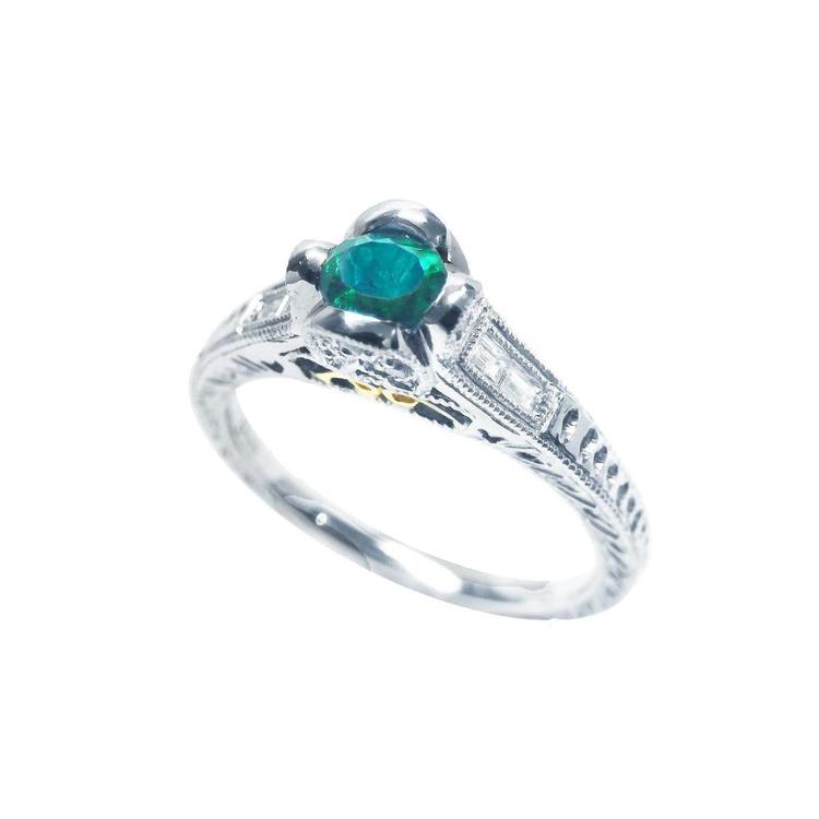 14K white gold ring with a 0.33 ct. oval-cut Colombian emerald and baguette diamond accents.