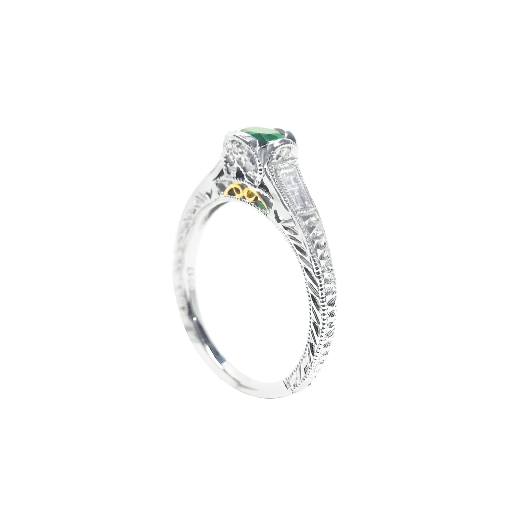 Oval-cut Colombian emerald ring in 14K white gold with baguette diamond accents and intricate filigree.