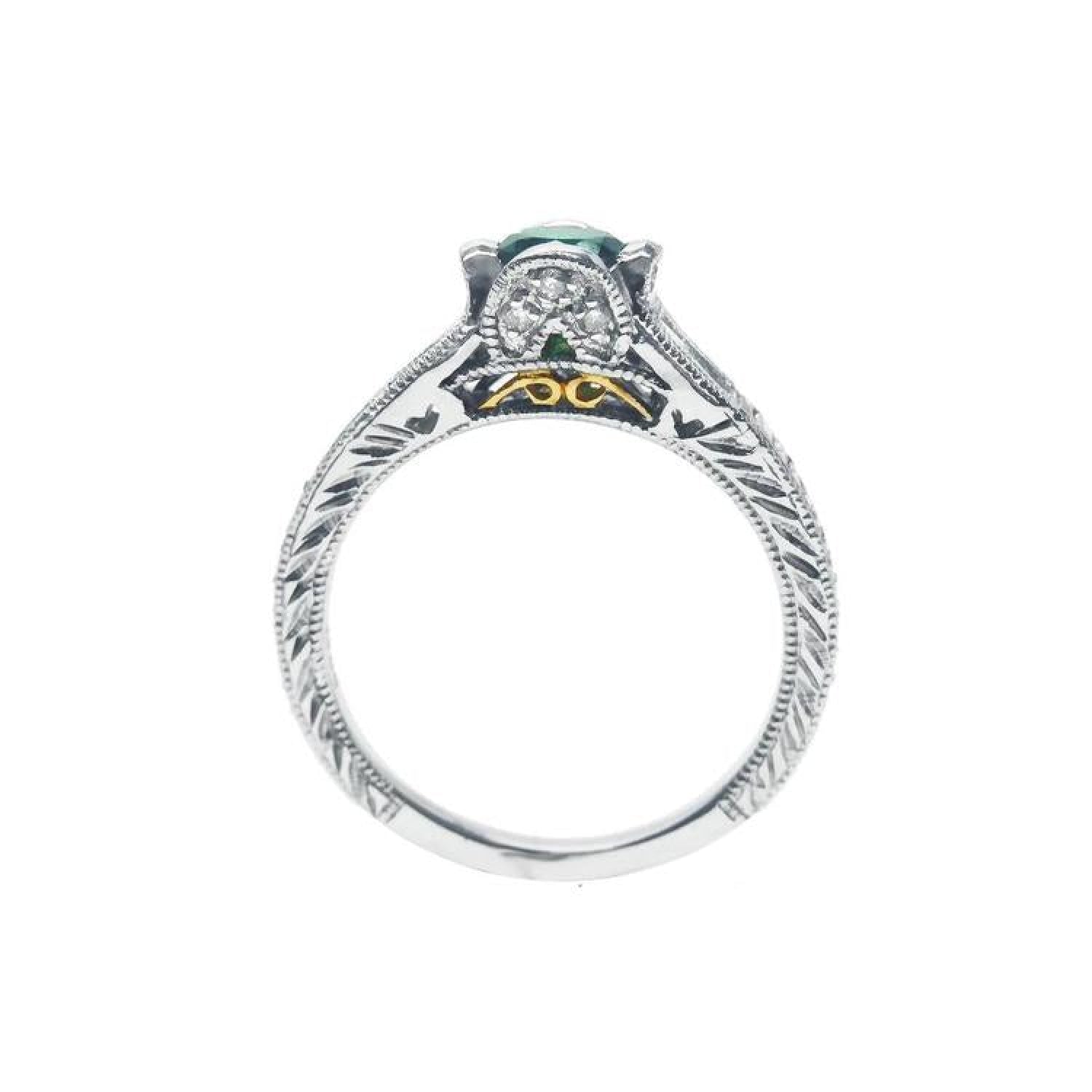 Oval-cut Colombian emerald ring in 14K white gold with diamond accents and intricate band engraving.