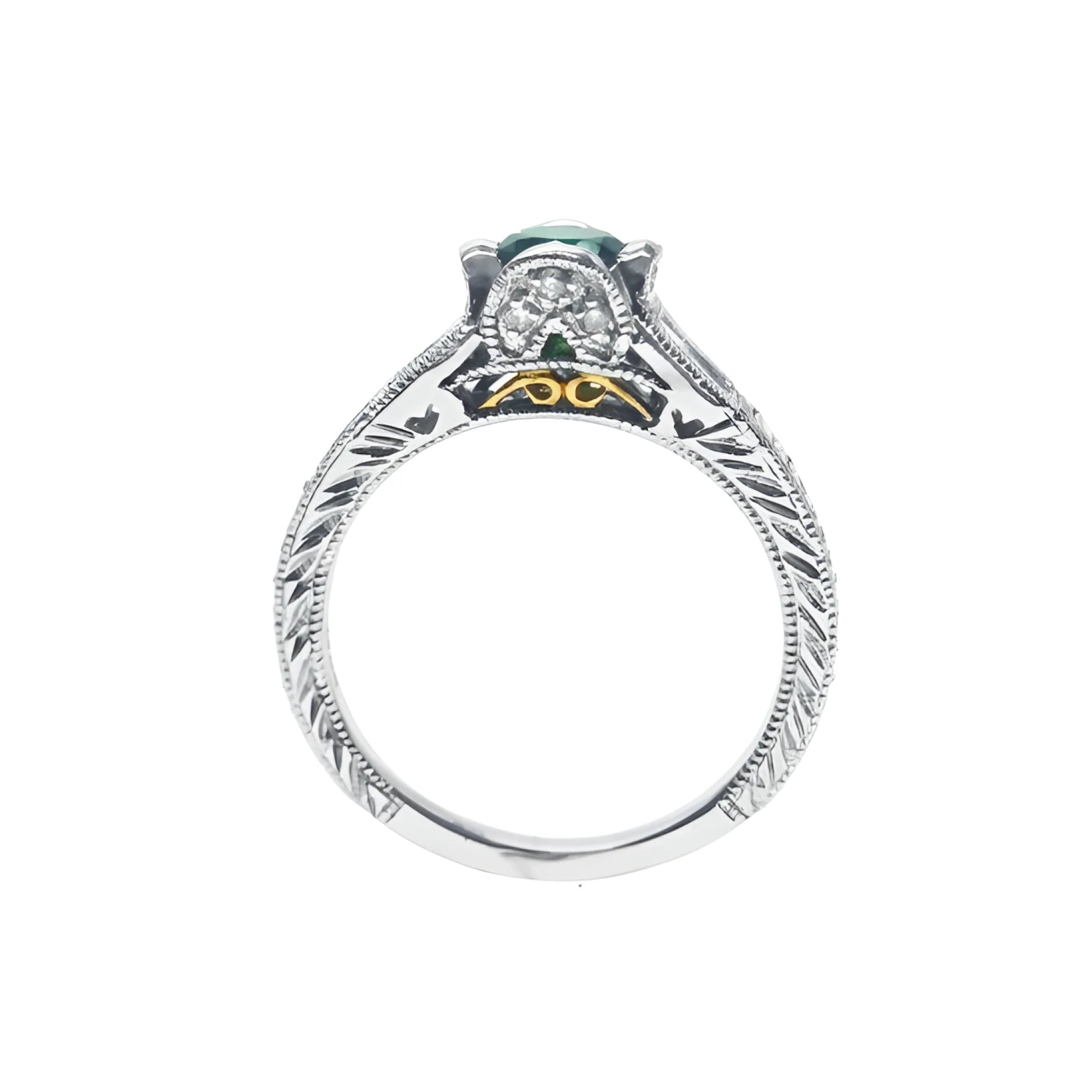 Oval-cut Colombian emerald ring in 14K white gold with diamond accents and intricate band engraving.