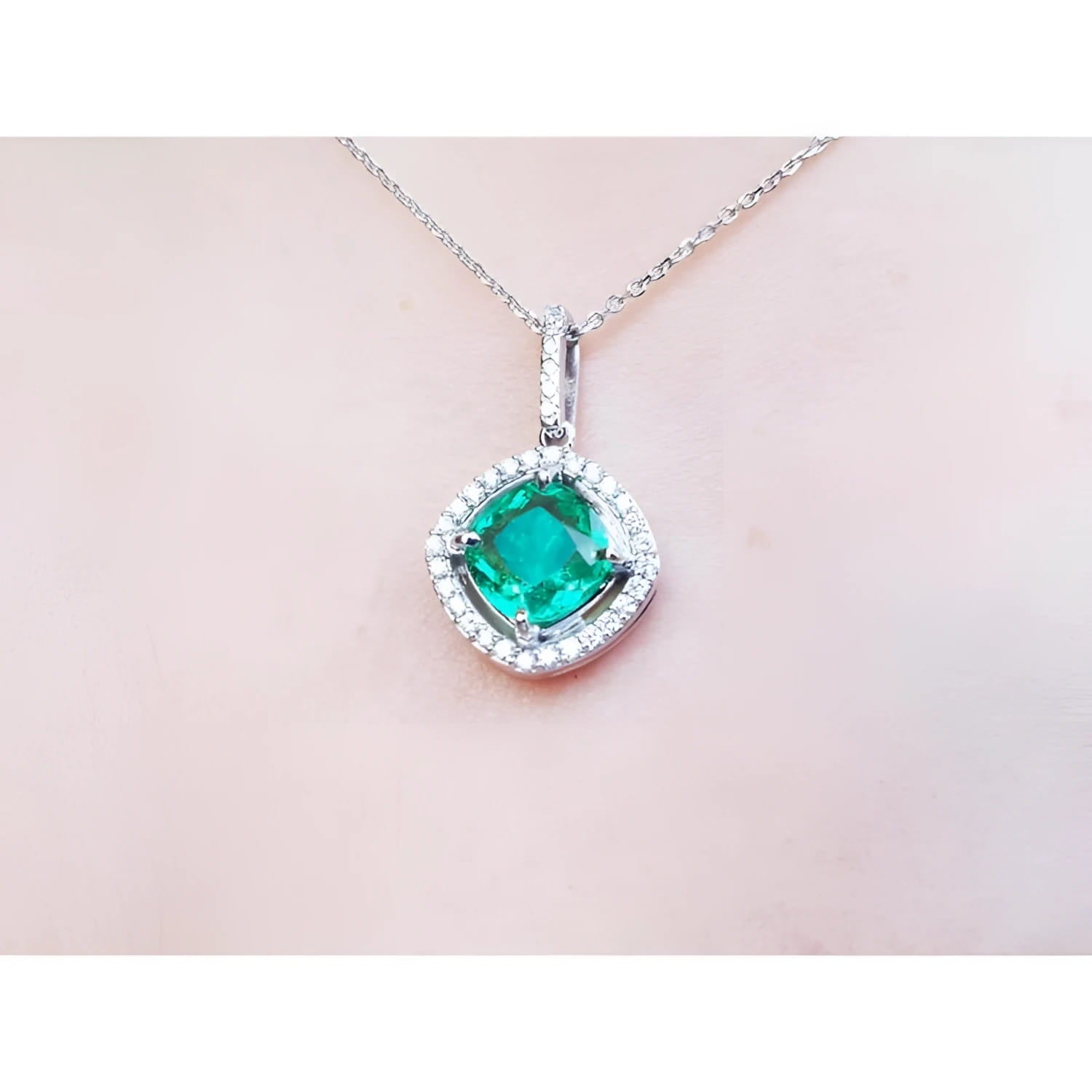 Cushion-cut Colombian emerald pendant with diamond halo on a delicate 14K white gold chain.
