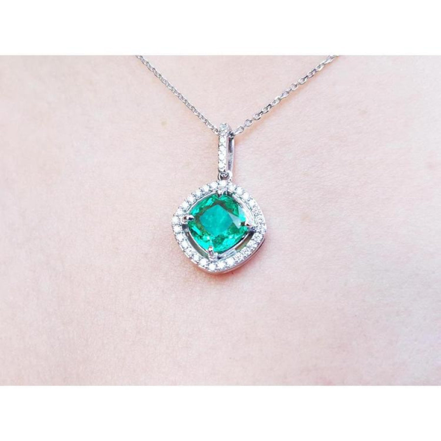Cushion-cut Colombian emerald pendant with diamond halo on a delicate 14K white gold chain.