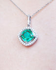 Emerald pendant necklace on a light pink background