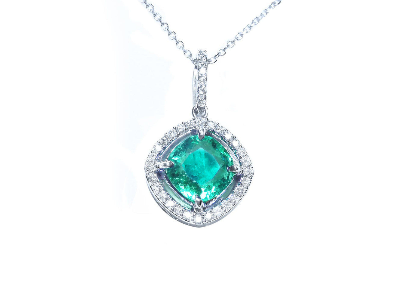 Emerald pendant with diamond halo on a white gold chain topside visible.