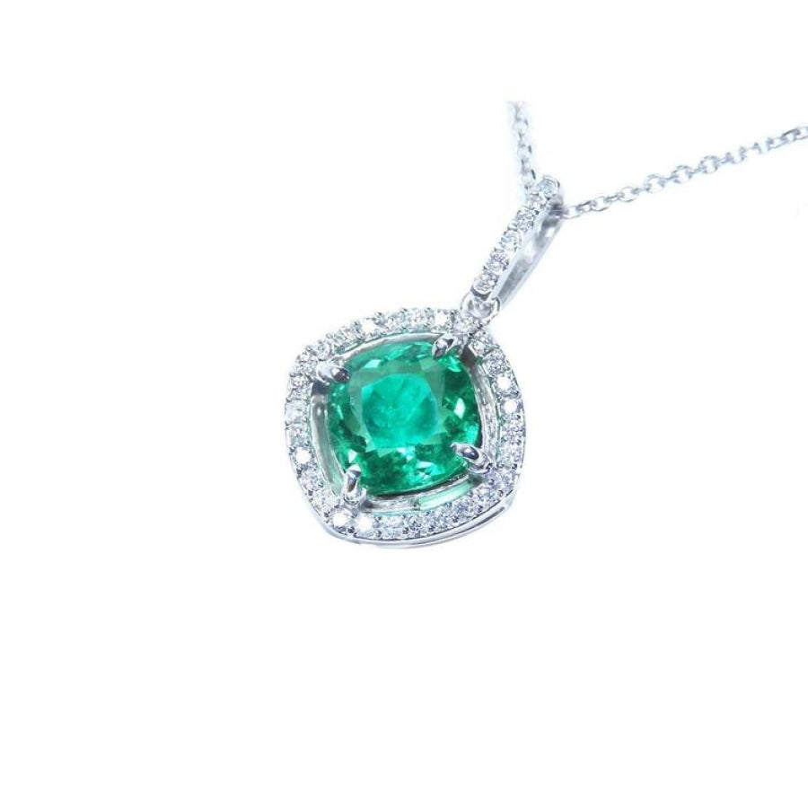 Cushion-cut Colombian emerald pendant with diamond halo in 14K white gold.
