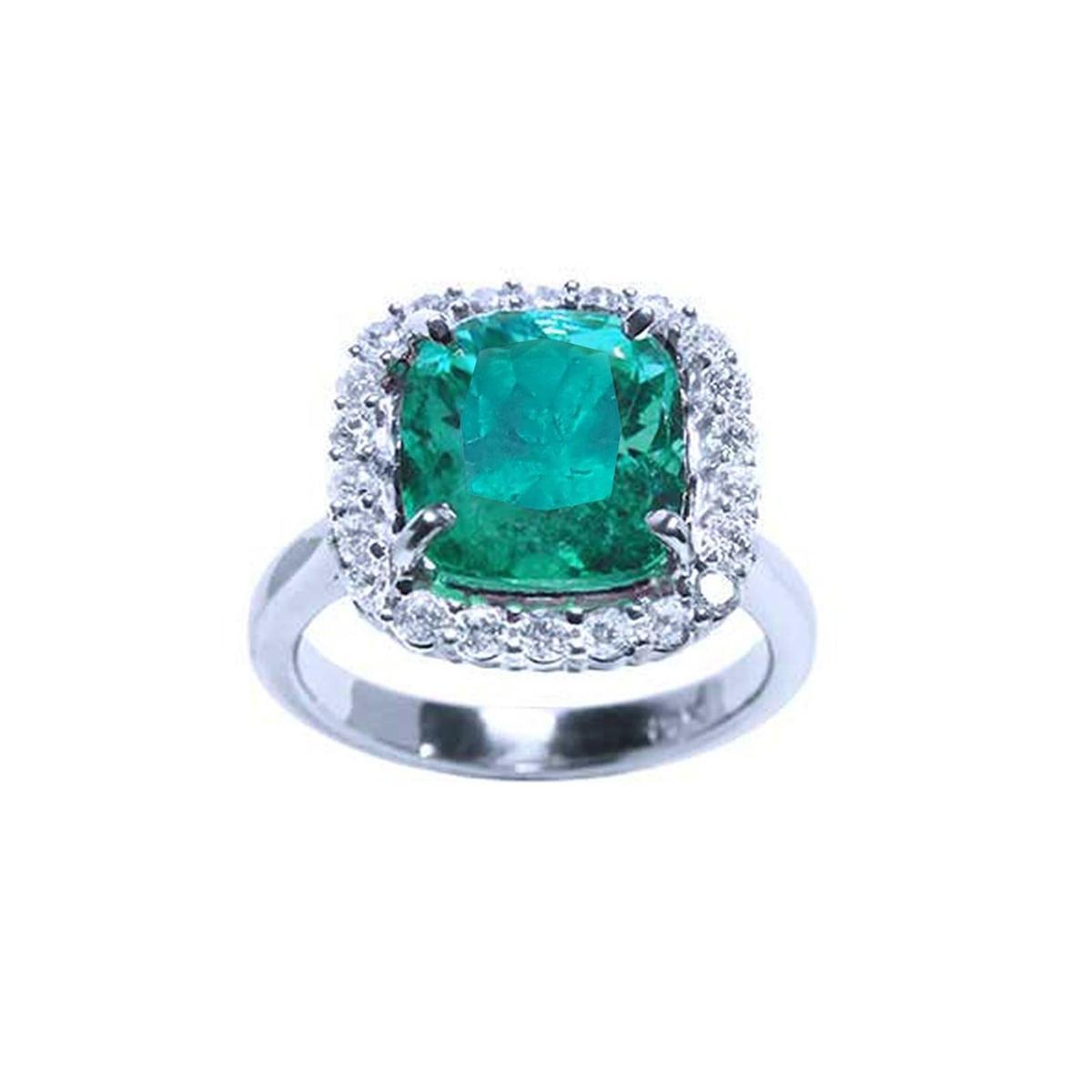 This cushion cut Colombian emerald ring with a halo diamond is positioned at the front, fully displaying the top stone.