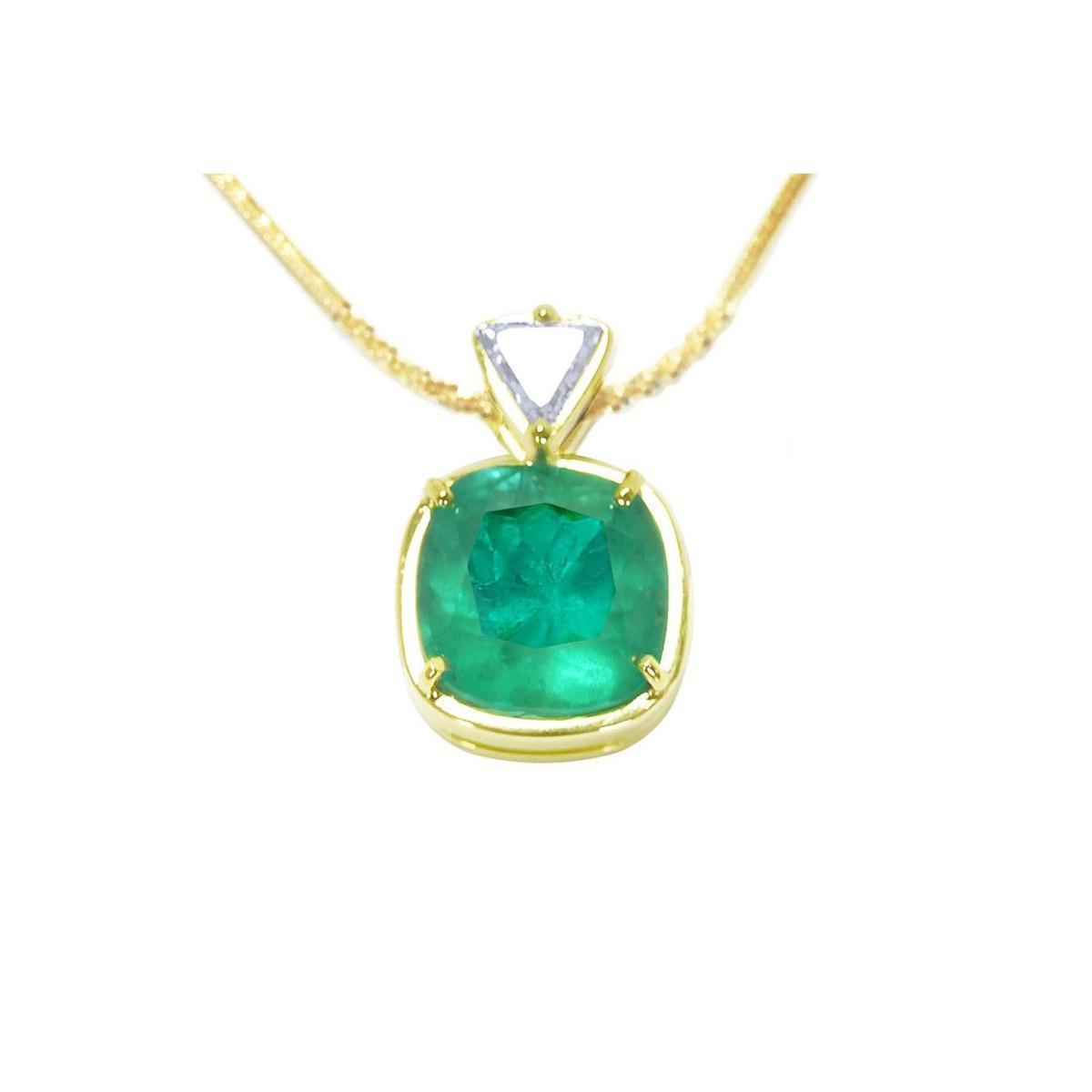 Gold necklace with a cushion cut natural emerald pendant on a white background