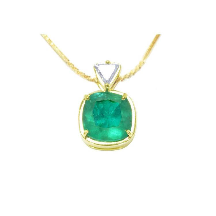 Gold necklace with a cushion cut natural emerald pendant on a white background