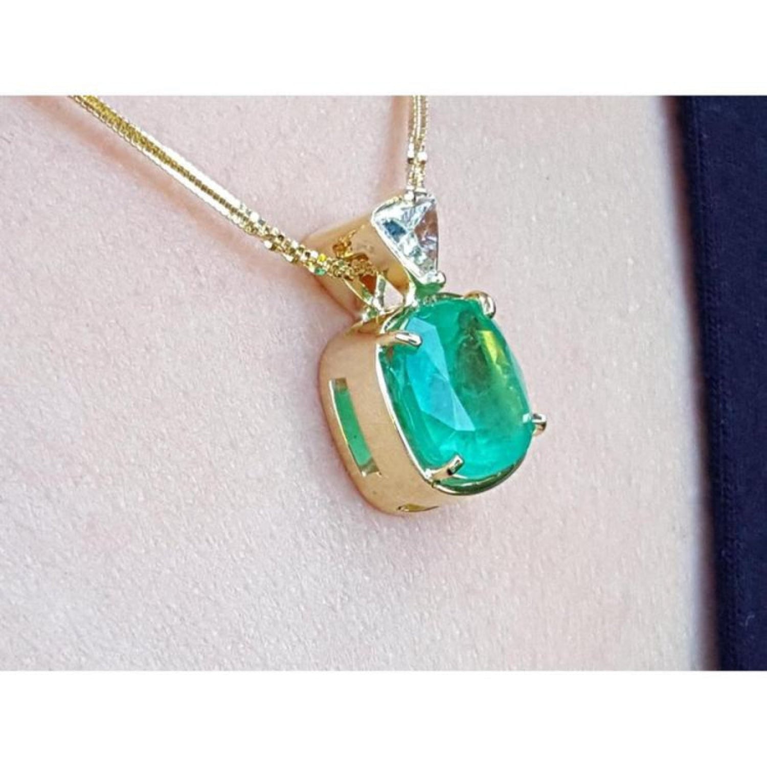 Cushion cut 4.84 ct. emerald pendant in 18K yellow gold on a delicate chain.