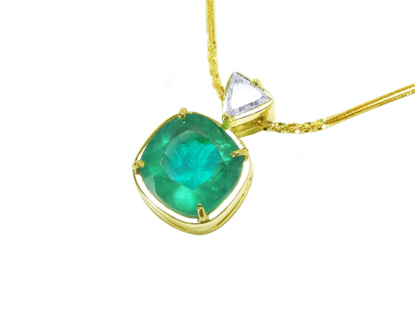 Gold necklace with a natural cushion cut emerald pendant on a white background