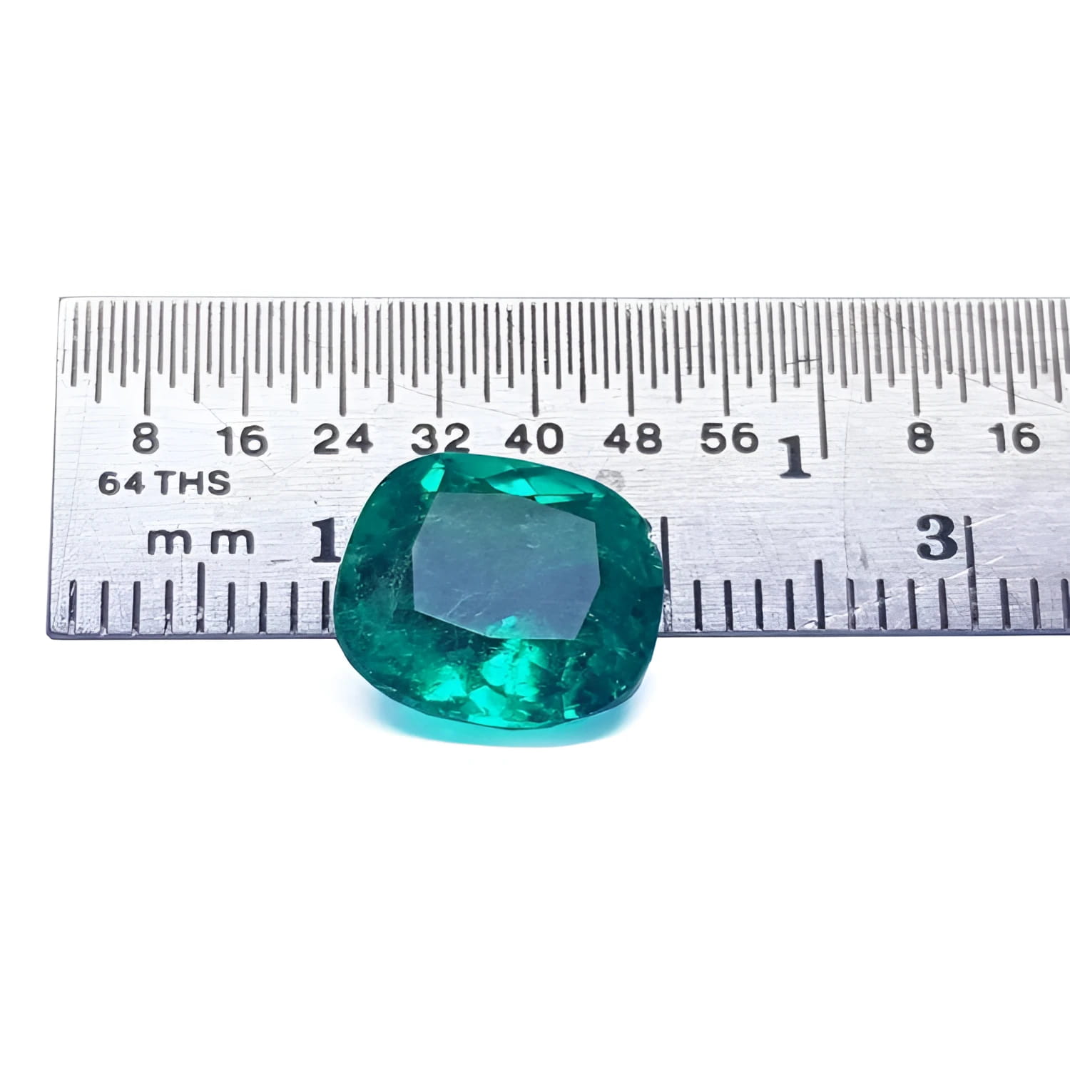 GIA certified 3.13 carat natural Colombian emerald with cushion cut, vivid bluish-green hue, next to a ruler.