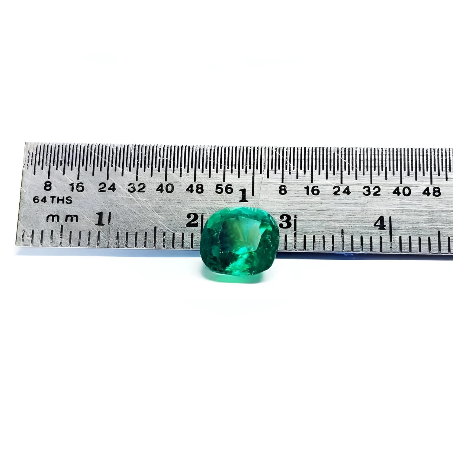 2.06 carat cushion cut Muzo Colombian emerald, sparkling medium-deep bluish green, shown with a ruler.