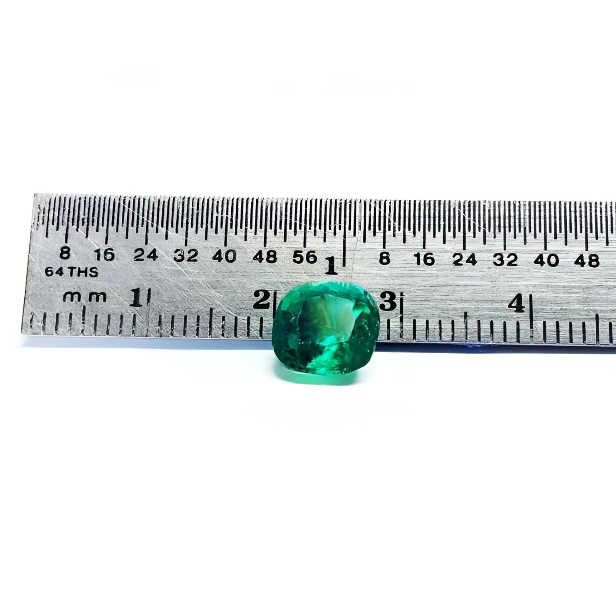 2.06 carat cushion cut Muzo Colombian emerald, sparkling medium-deep bluish green, shown with a ruler.