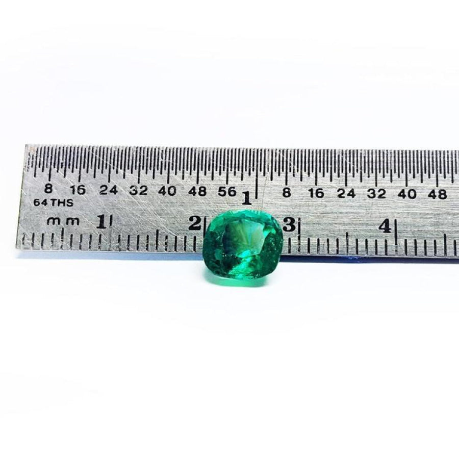2.06 carat cushion cut Muzo Colombian emerald, sparkling medium-deep bluish green, shown with a ruler.