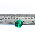 Cushion cut loose emerald from muzo Colombia, next to a ruler for measure size