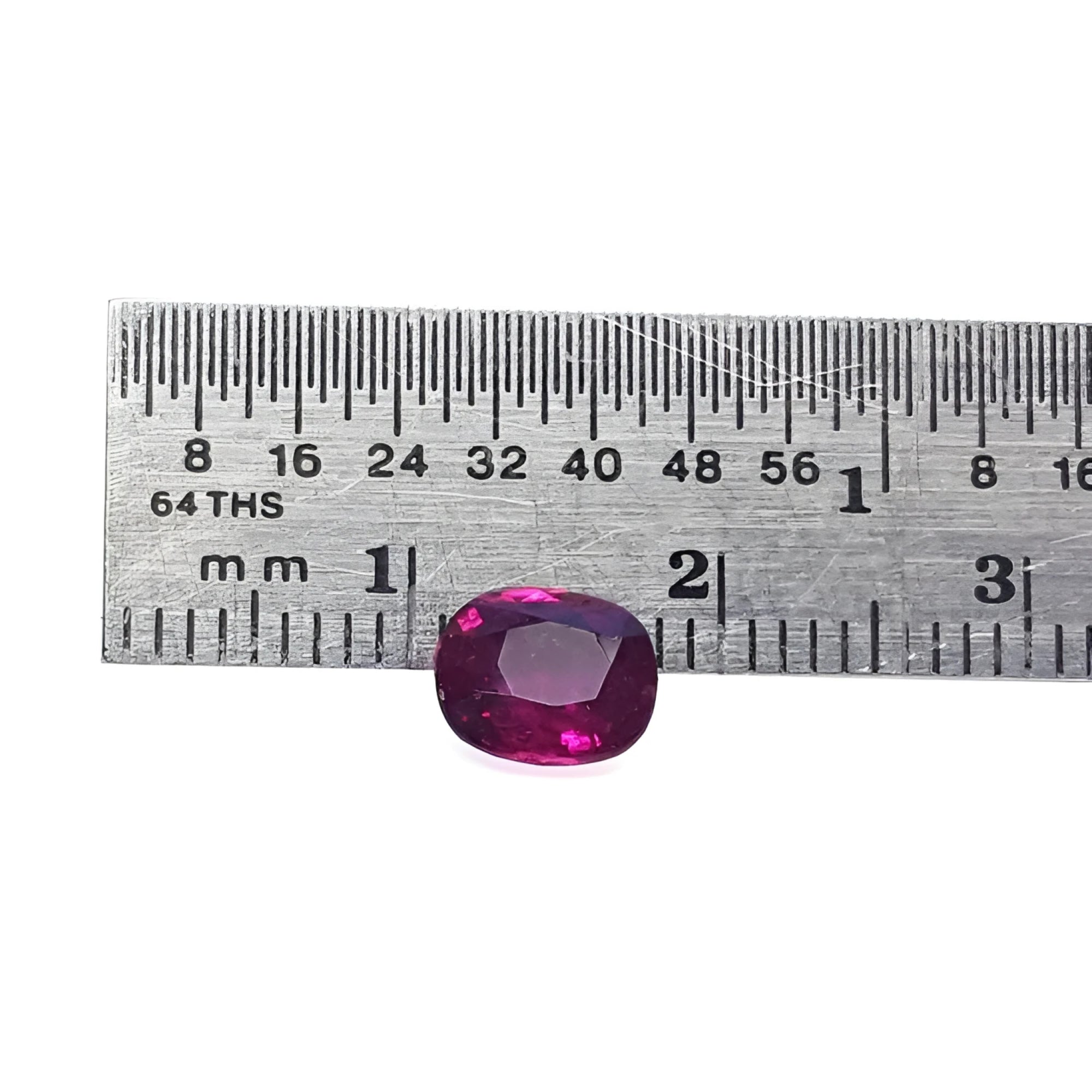 Vibrant red 1.18 carat cushion-cut natural ruby gemstone next to a ruler for scale.