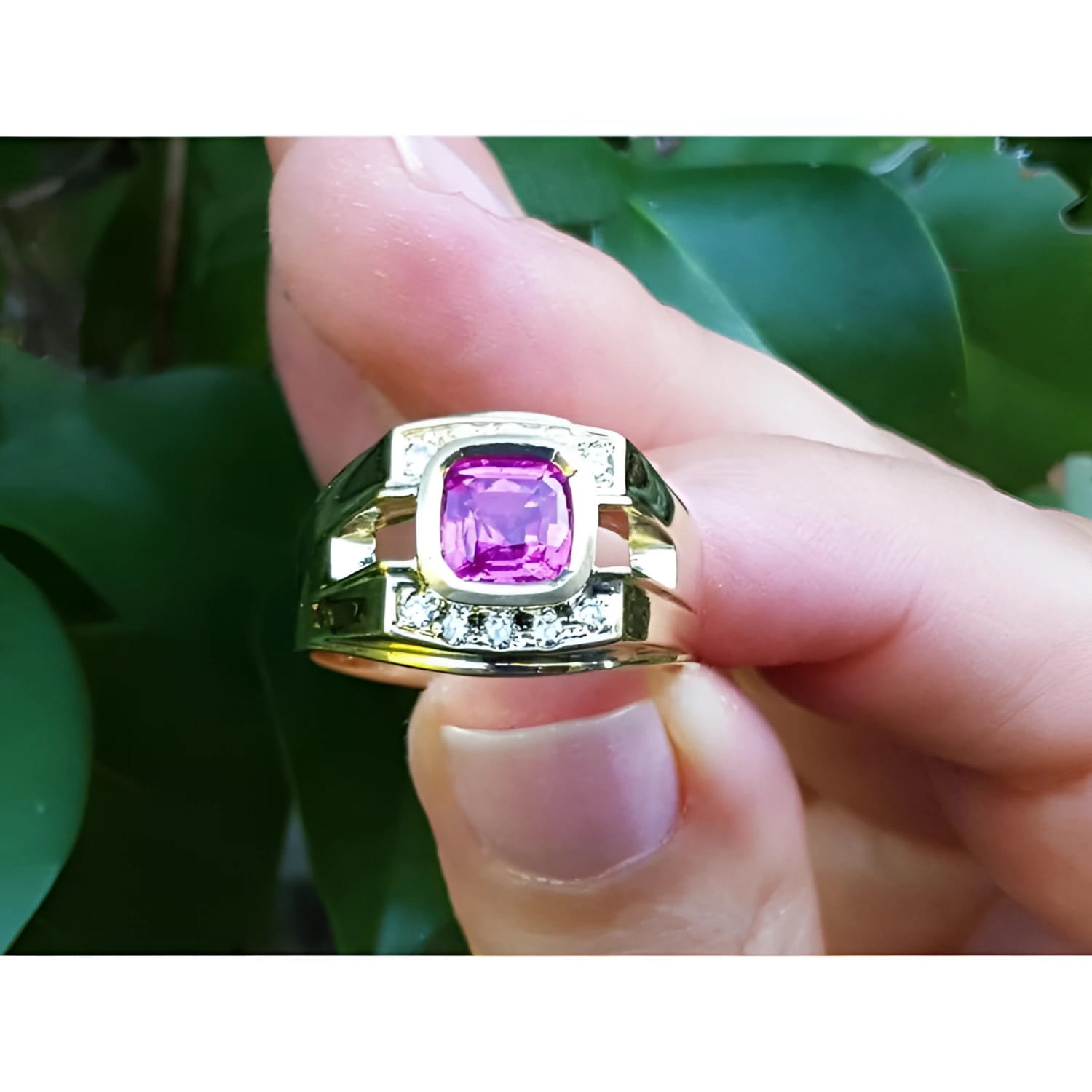 Men's 18K yellow gold ring with a bezel-set cushion-cut purplish-pink sapphire and diamond accents.