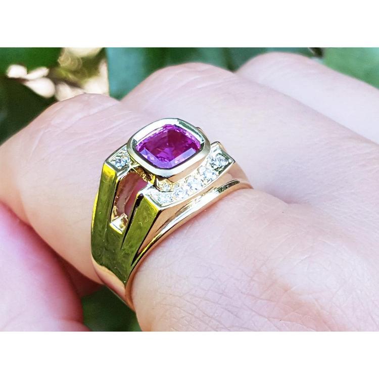 Men's 18K yellow gold ring with a bezel-set cushion-cut purplish-pink sapphire and diamond accents.