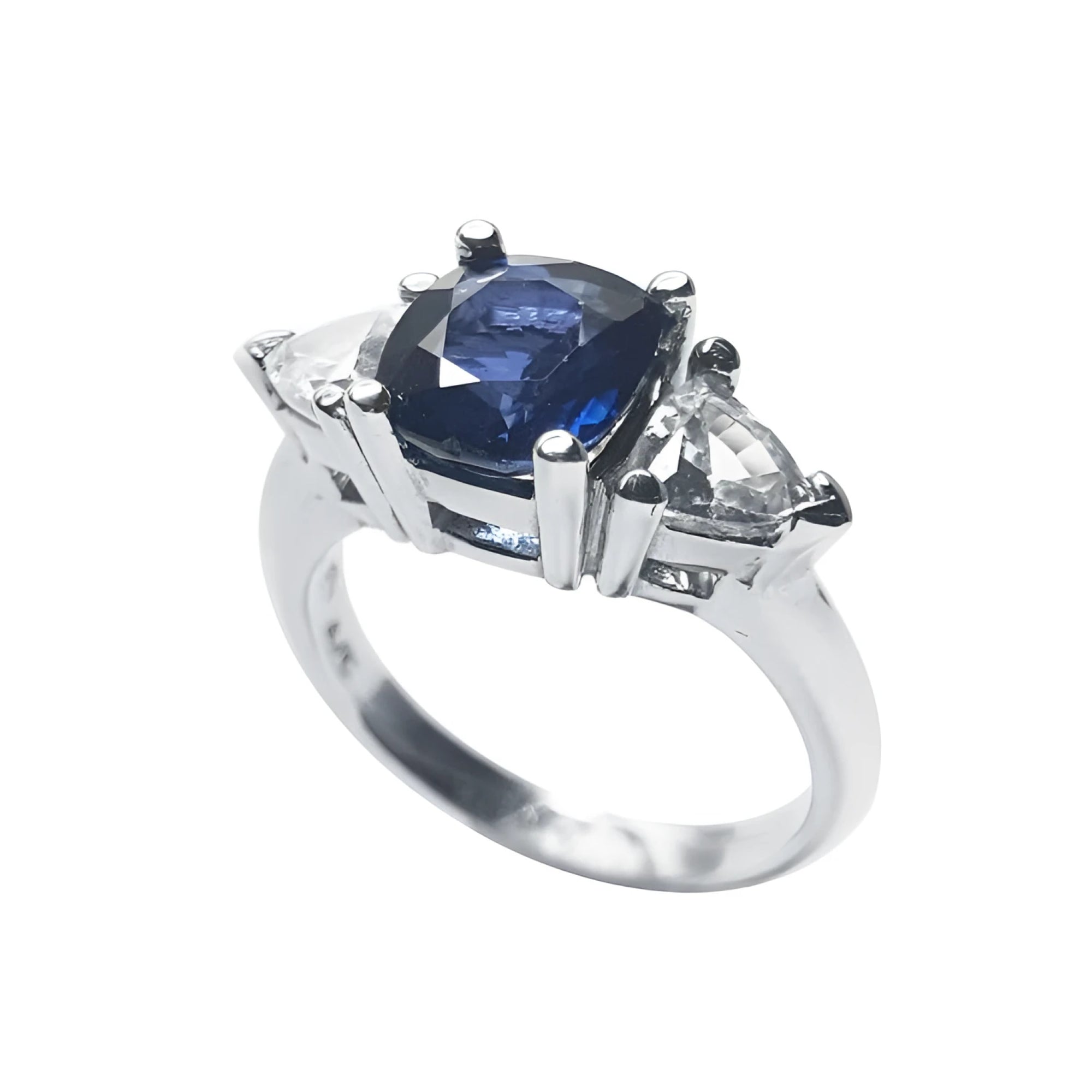 Deep blue cushion cut sapphire ring with trillion side sapphires in white gold.