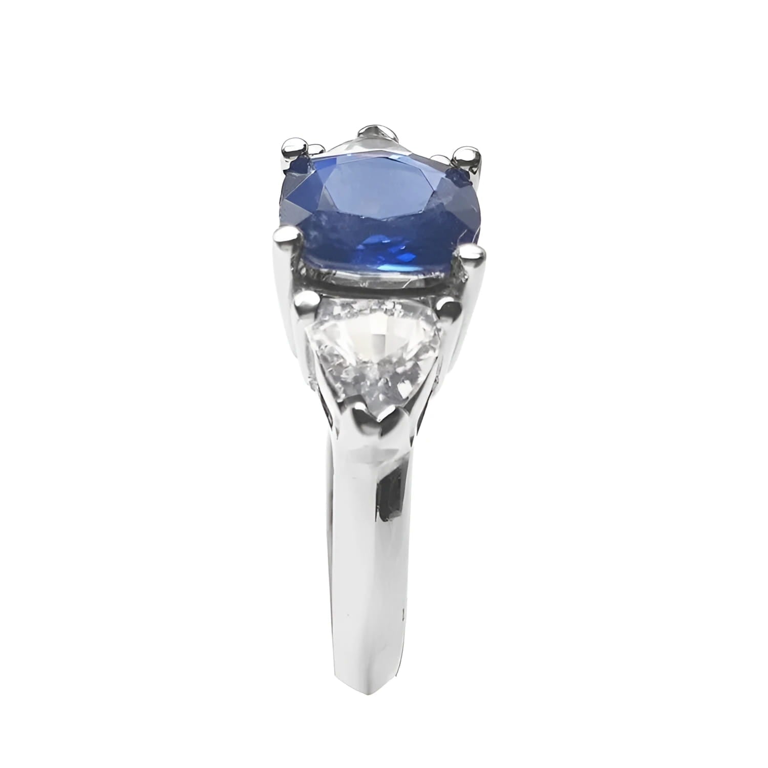 Cushion cut deep blue sapphire ring with trillion side sapphires in white gold.