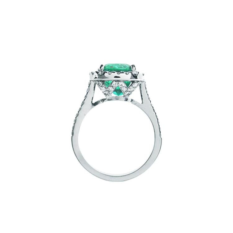 Cushion cut 3.92 ct. deep bluish-green natural emerald ring with diamond halo in 14K white gold.