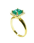 A yellow gold emerald cushion cut ring on its half side profile view from the top to the band.
