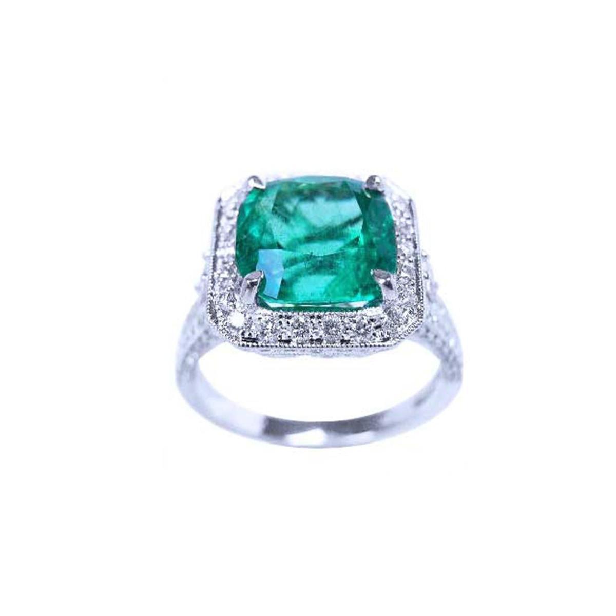 A cushion cut emerald white gold ring for women displaying a halo diamond and side profile.