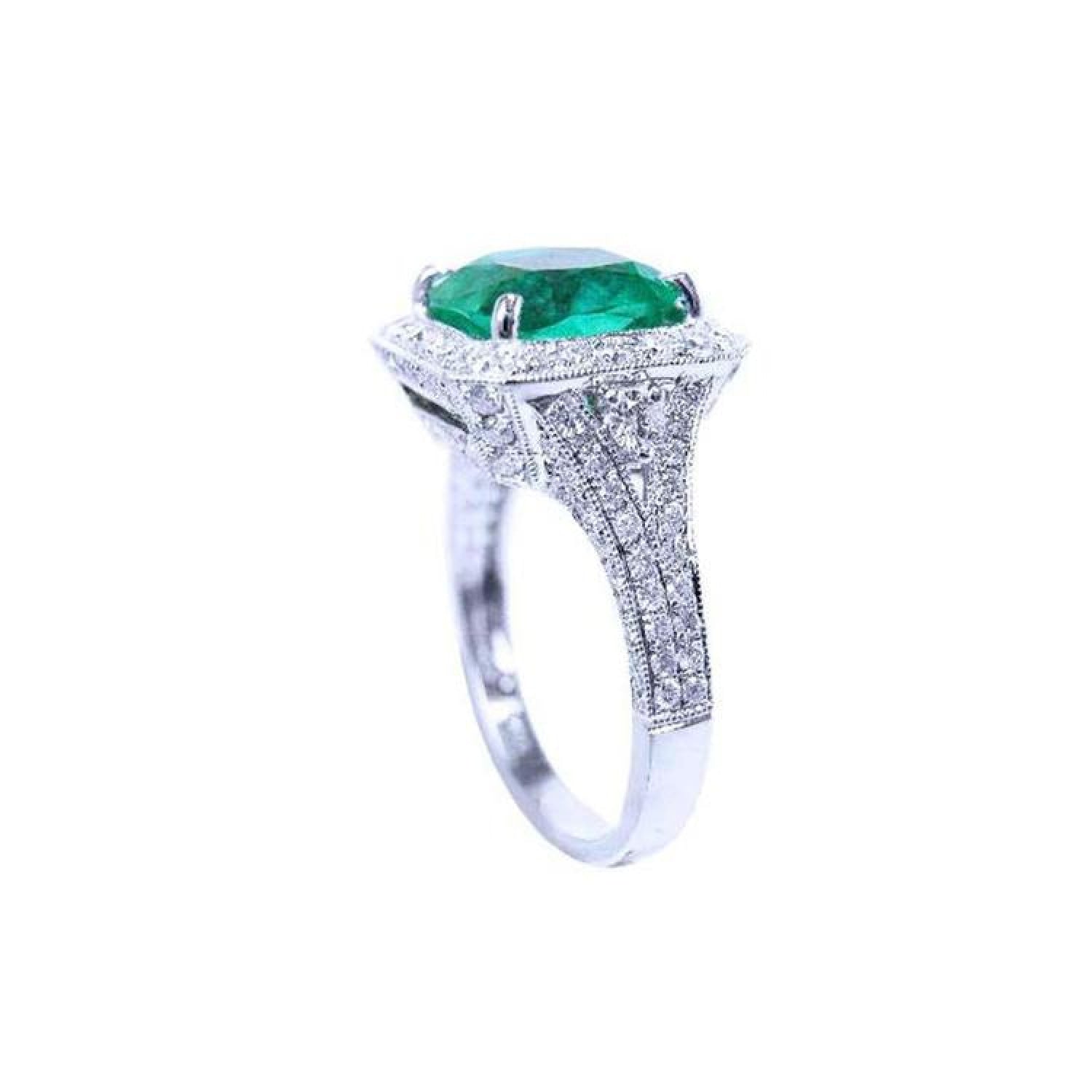 Cushion cut 3.68 ct emerald engagement ring with diamond halo and pavé band in 18K white gold.