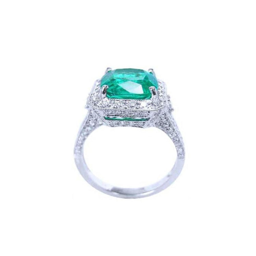 Cushion cut 3.68 ct Colombian emerald engagement ring with diamond halo in 18K white gold.