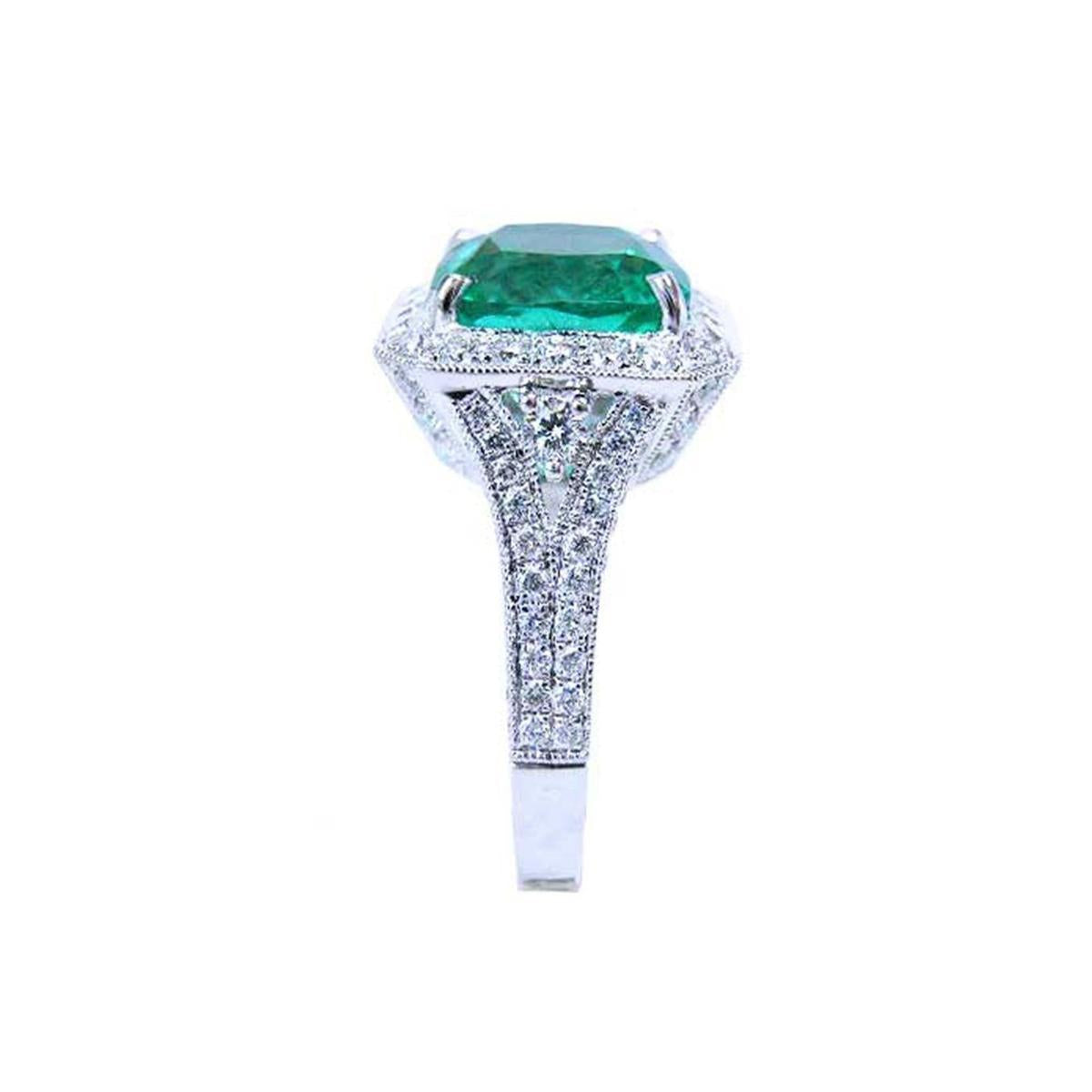A cushion cut emerald and accent diamond engagement ring displaying the top and side profile.