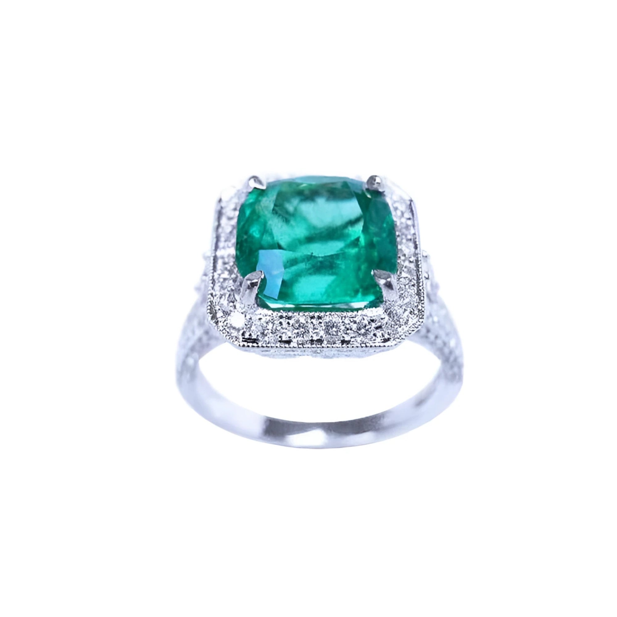 A cushion cut emerald white gold ring for women displaying a halo of natural diamond.