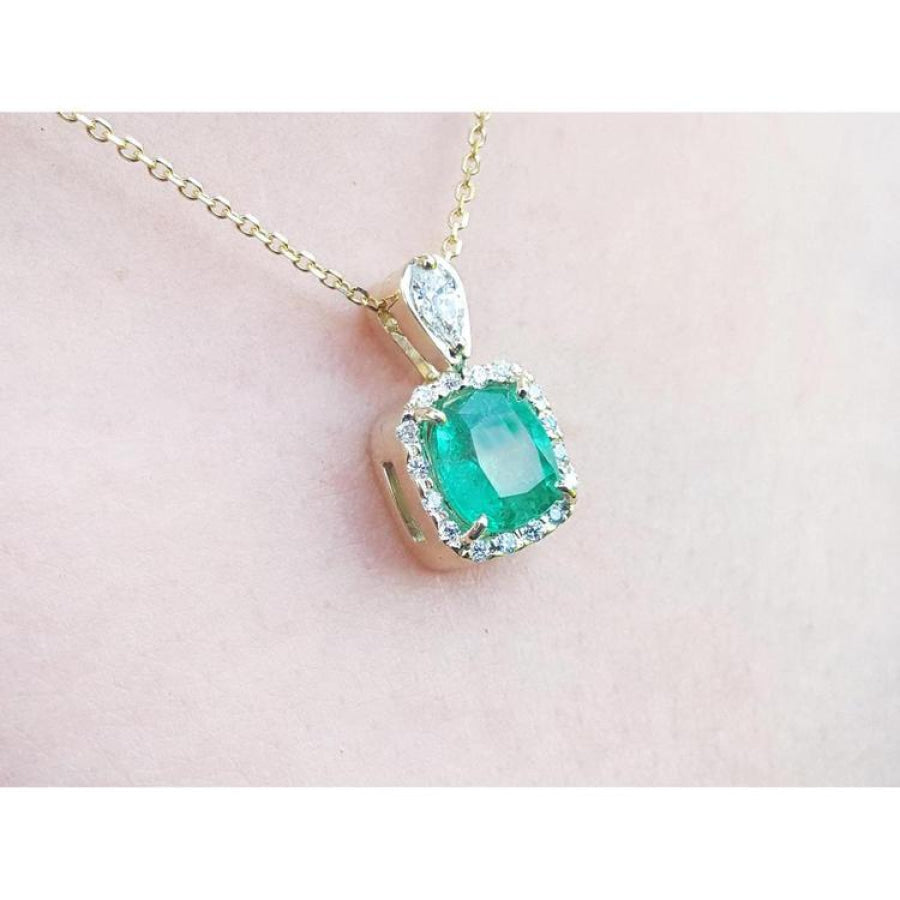 1.99 ct cushion-cut emerald halo pendant with natural diamonds on a 14K yellow gold chain.
