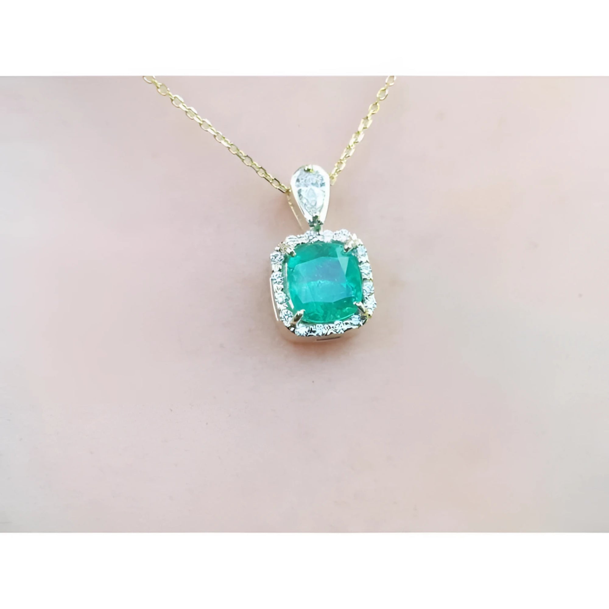1.99 ct. cushion-cut emerald halo pendant with natural diamonds on a 14K yellow gold chain.