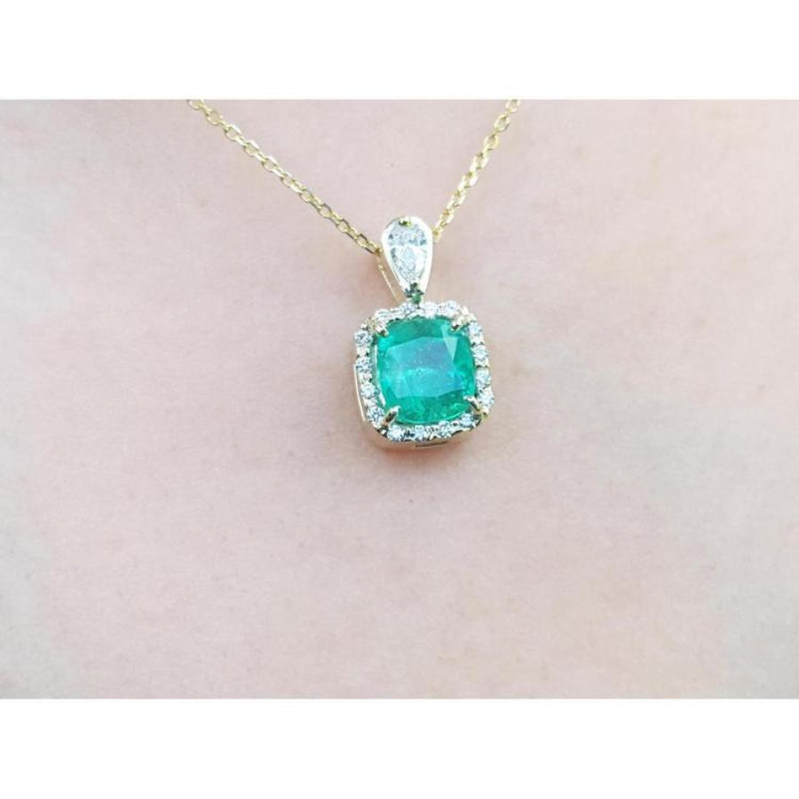 1.99 ct. cushion-cut emerald halo pendant with natural diamonds on a 14K yellow gold chain.