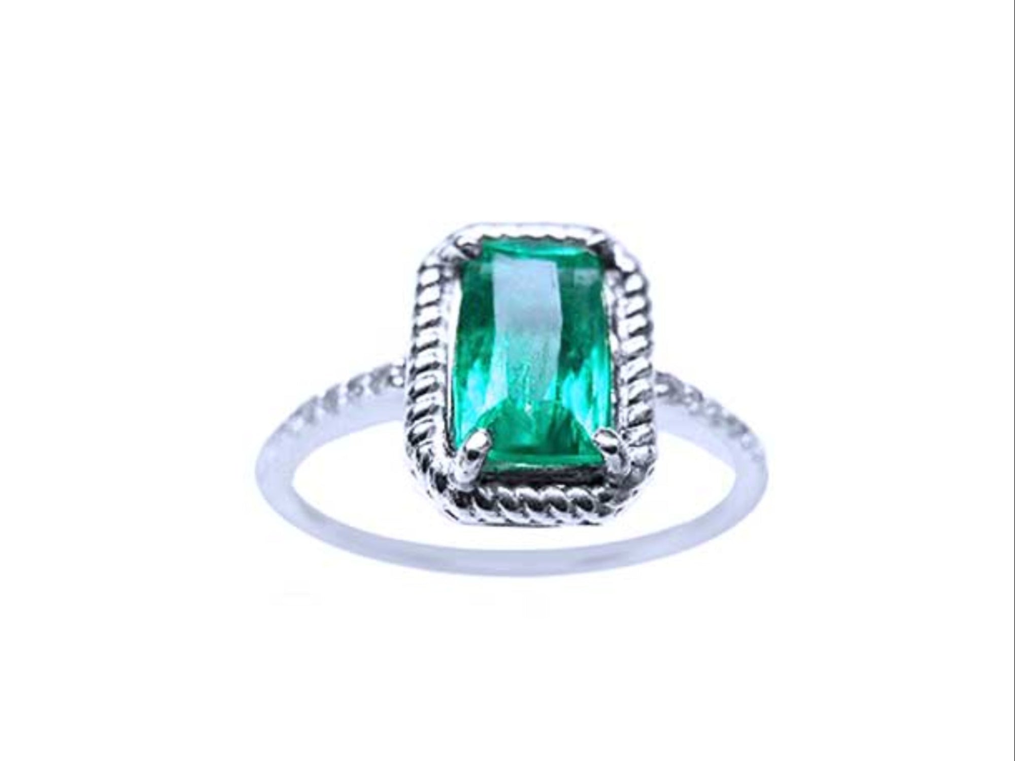 A cushion cut emerald ring in white gold displaying its topside encircled with rope like frame design.