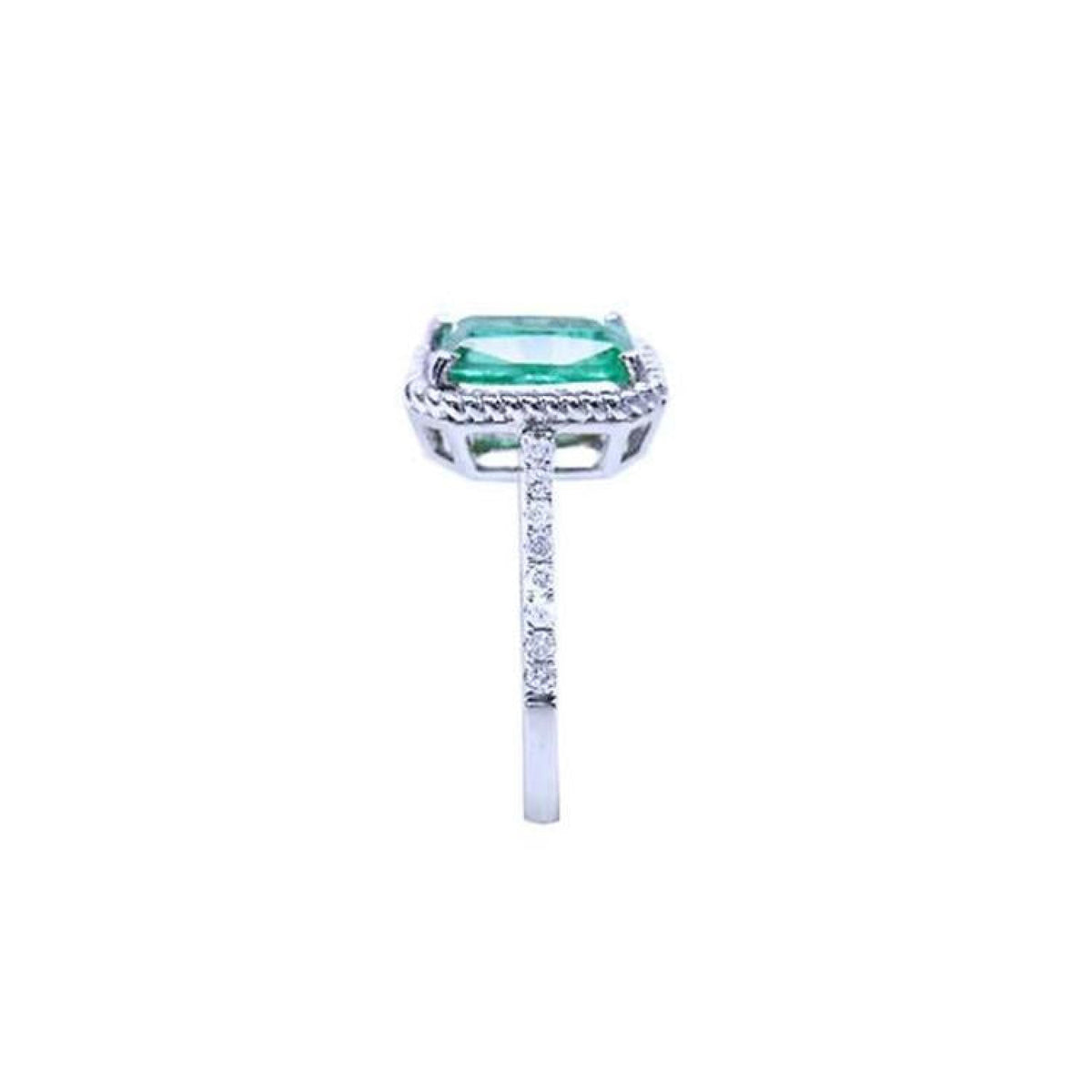 14K white gold cushion-cut emerald ring with diamond halo and rope detailing.