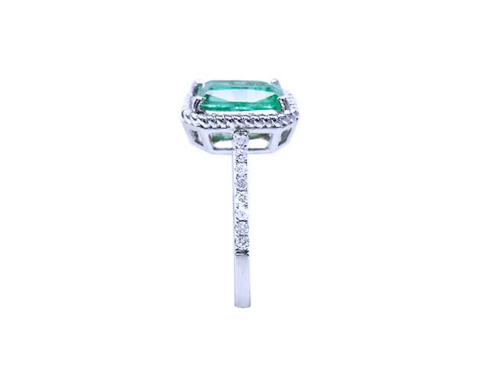 A clean side profile perspective of this natural emerald ring showing the top setting and band with diamonds studded.