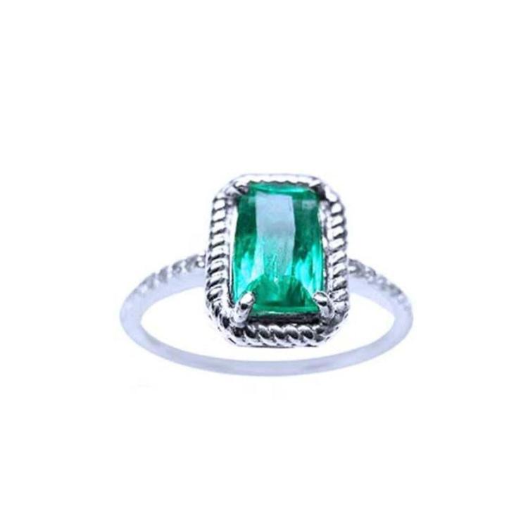 A cushion cut emerald ring may's birthstone in white gold encircled with rope like frame design.