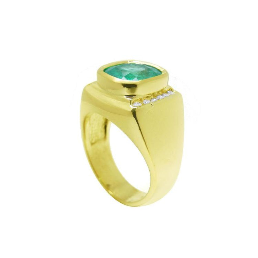 Men's 18k yellow gold ring with a cushion-cut emerald and channel-set diamonds.